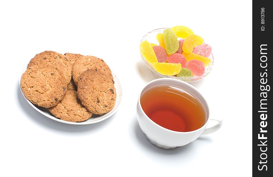 Fruit candy, oats cookies and a cup with tea.