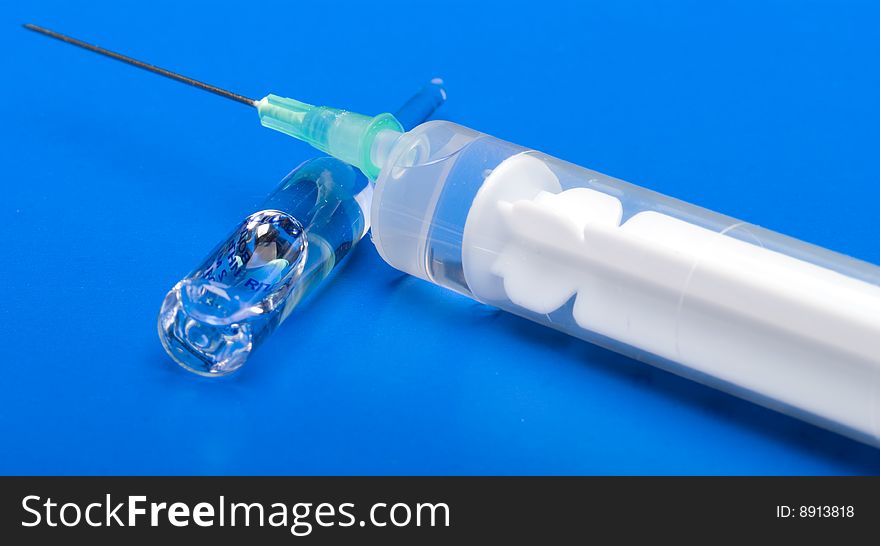 Syringe and ampoule on a dark blue background. Syringe and ampoule on a dark blue background.