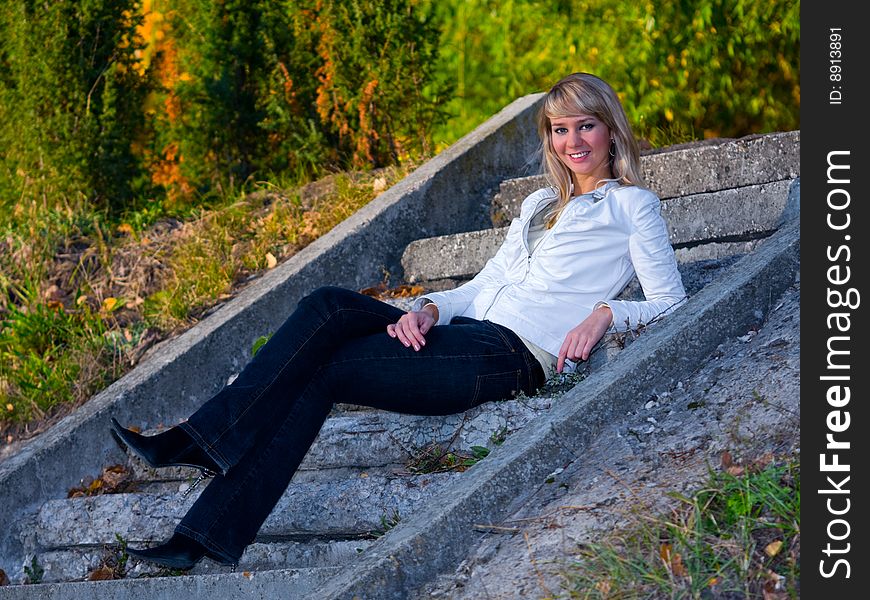 Pretty girl sitting on stone stair steps