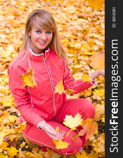 Pretty girl playing with yellow maple leaves - shallow DOF