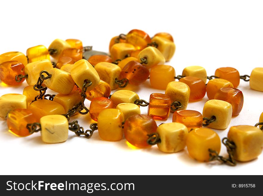 Necklace from natural amber with a fastener in the form of heart on a white background. Necklace from natural amber with a fastener in the form of heart on a white background