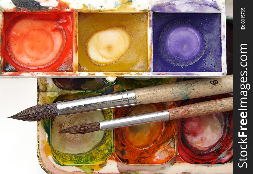 Dirty watercolor paints set with brushes after using. Dirty watercolor paints set with brushes after using