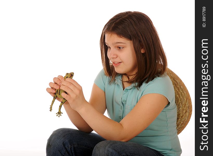 A skiddish preteen girl studying a spotted green frog as she holds him in both hands. Isolated on white. A skiddish preteen girl studying a spotted green frog as she holds him in both hands. Isolated on white.