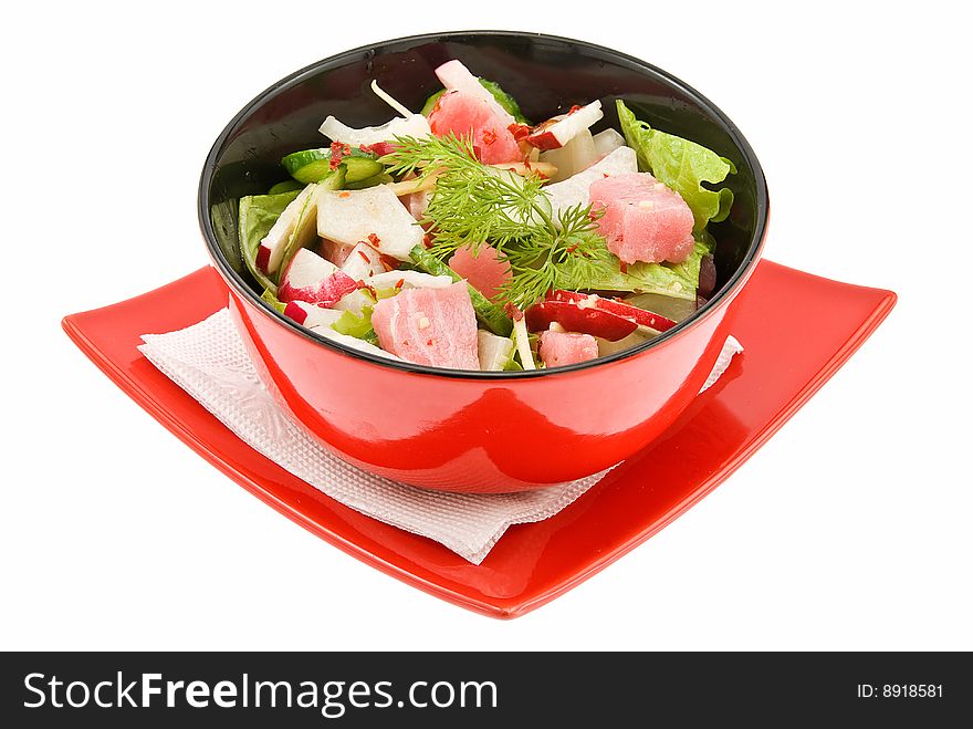 Salad with tunny on red plate isolated