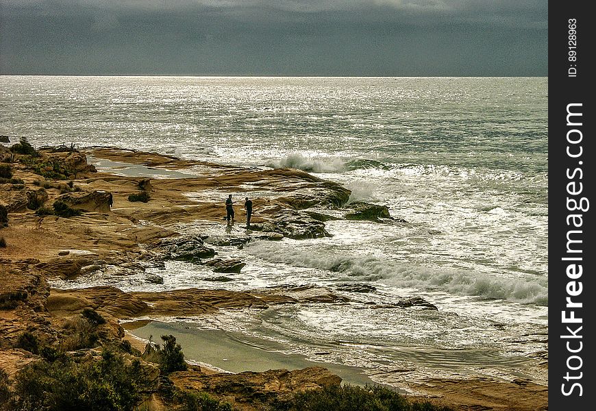 Men On Rocky Beach In Mediterranean