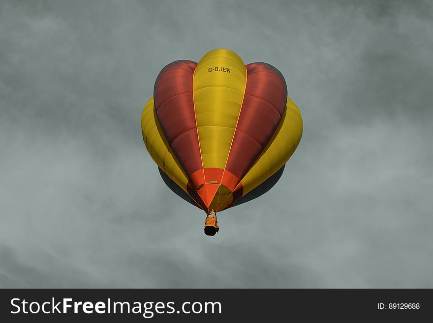 Red And Yellow Hot Air Balloon Under Sea Of Clouds