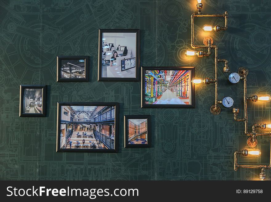 A wall with framed pictures and retro lighting. A wall with framed pictures and retro lighting.