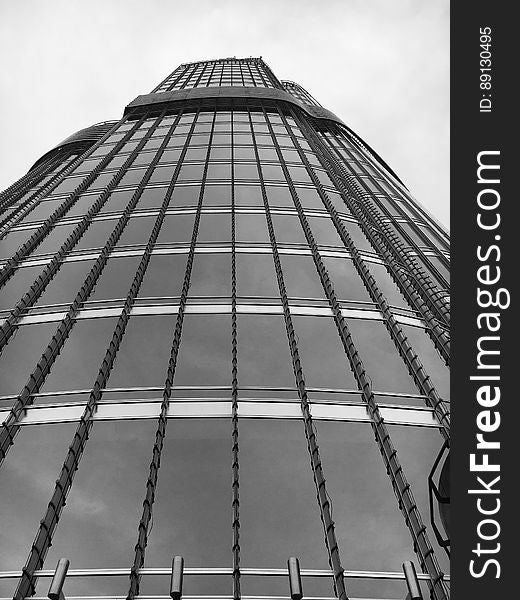 A low-angle view of a skyscraper in black and white. A low-angle view of a skyscraper in black and white.