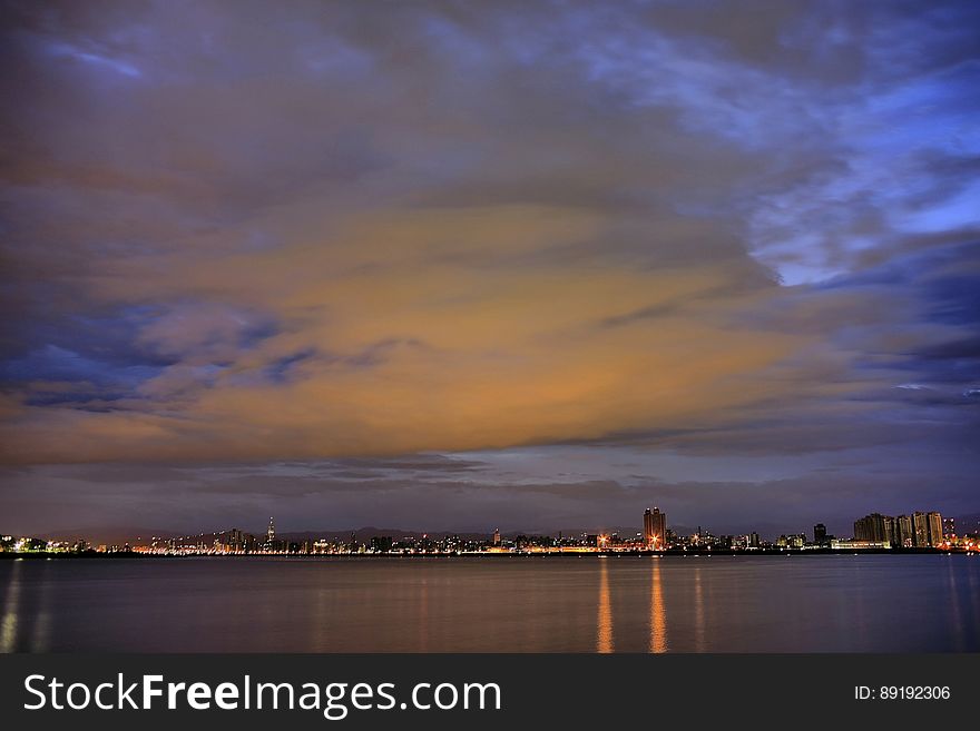 City Light Reflecting On Calm Waters Night Time