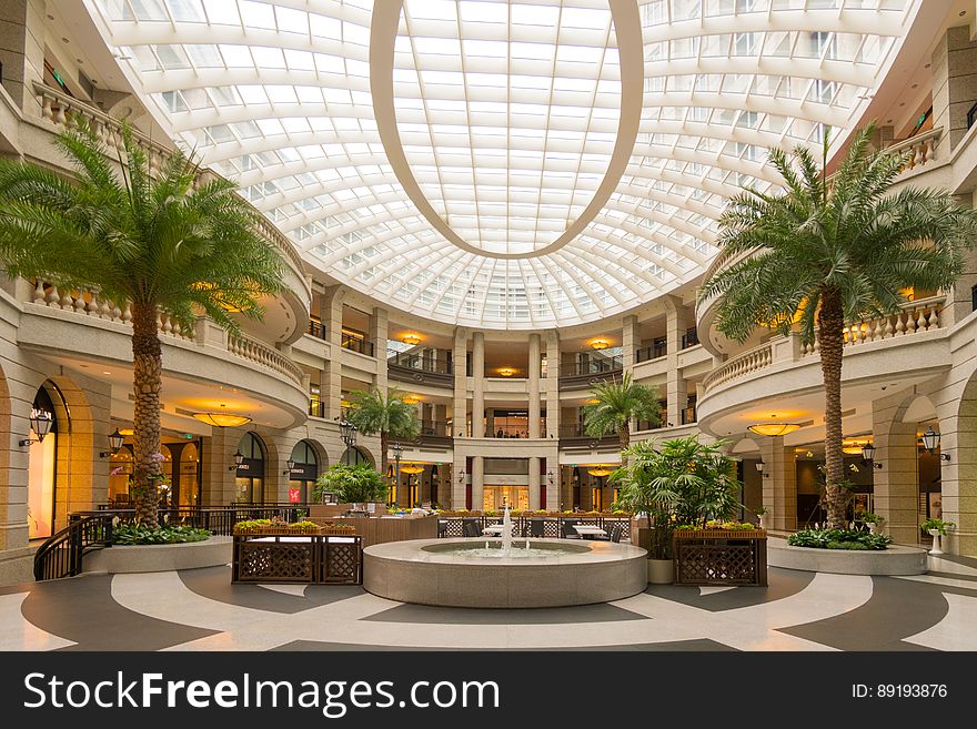 Fountain in center or contemporary lobby of modern mall with sunlight. Fountain in center or contemporary lobby of modern mall with sunlight.
