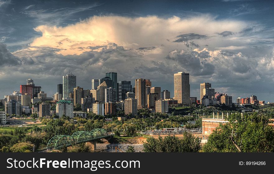 City skyline with modern skyscrapers against cloudy skies at sunset. City skyline with modern skyscrapers against cloudy skies at sunset.