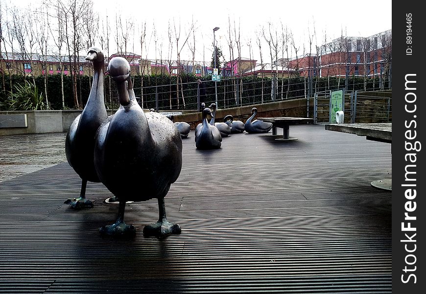 Statues of ducks on pier