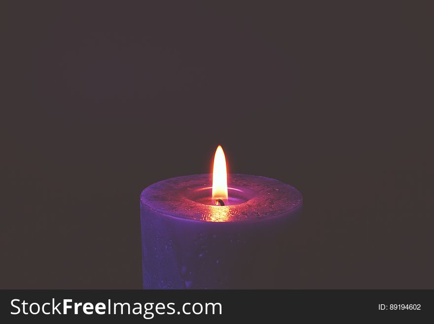 Purple candle with burning wick with copy space. Purple candle with burning wick with copy space.