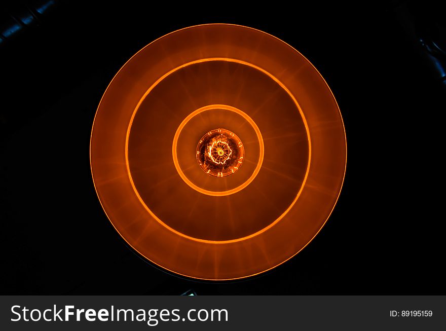 A close up of a burning lightbulb seen from above. A close up of a burning lightbulb seen from above.
