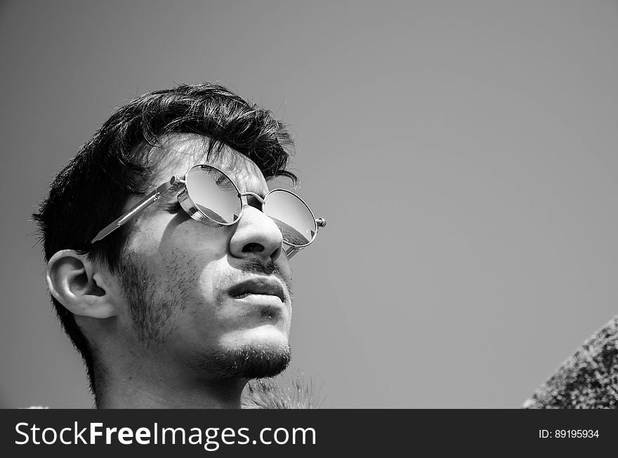 Profile of young man wearing sunglasses outdoors in black and white. Profile of young man wearing sunglasses outdoors in black and white.