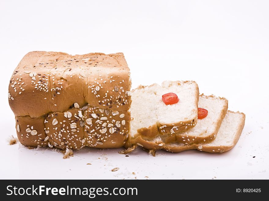 White background, bread in peieces, covered with til seed, cornmeal, tomato pieces on. White background, bread in peieces, covered with til seed, cornmeal, tomato pieces on
