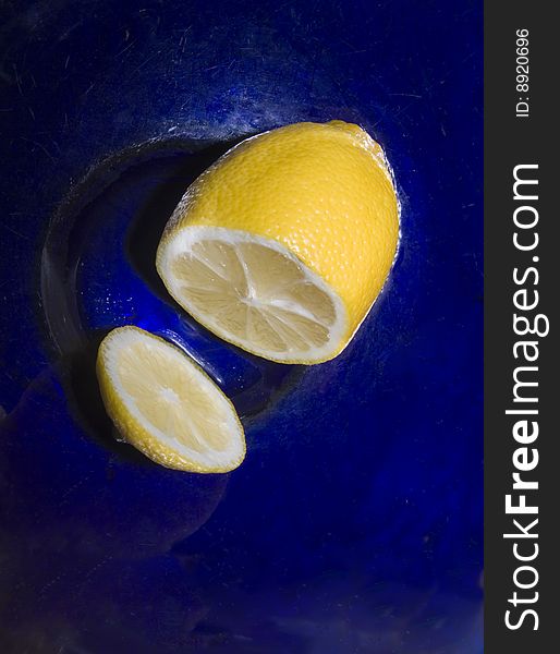 Lemon cut in dark blue glass bowl. Lemon cut in dark blue glass bowl