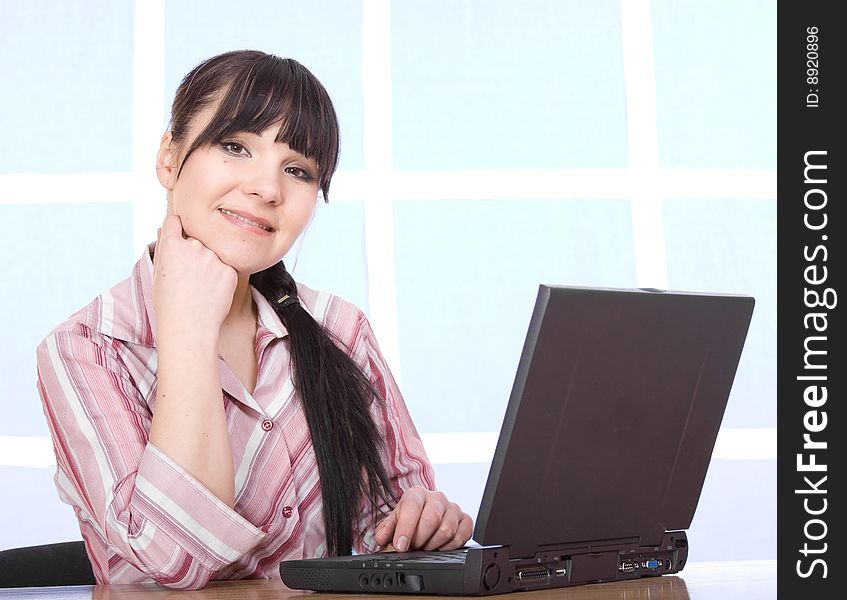 Happy brunette woman with laptop at home