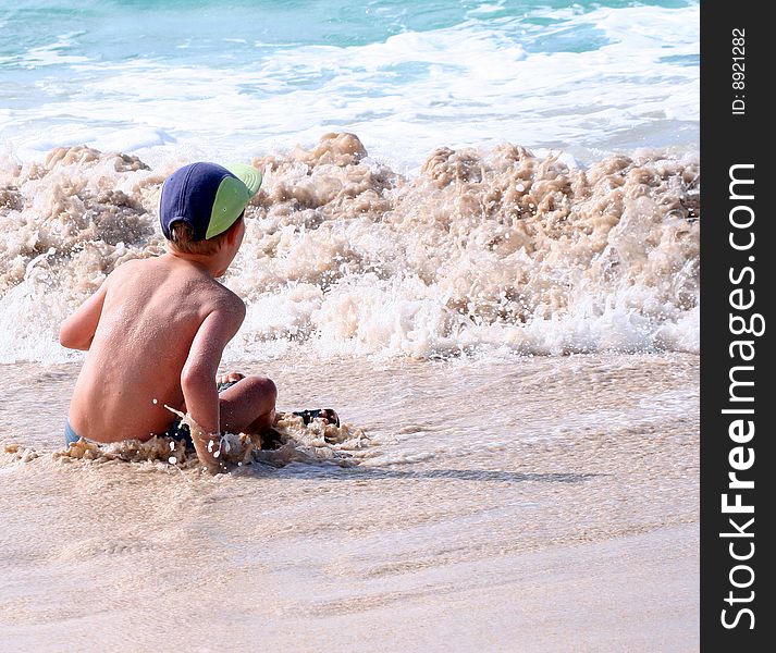 A young boy is playing on the beach