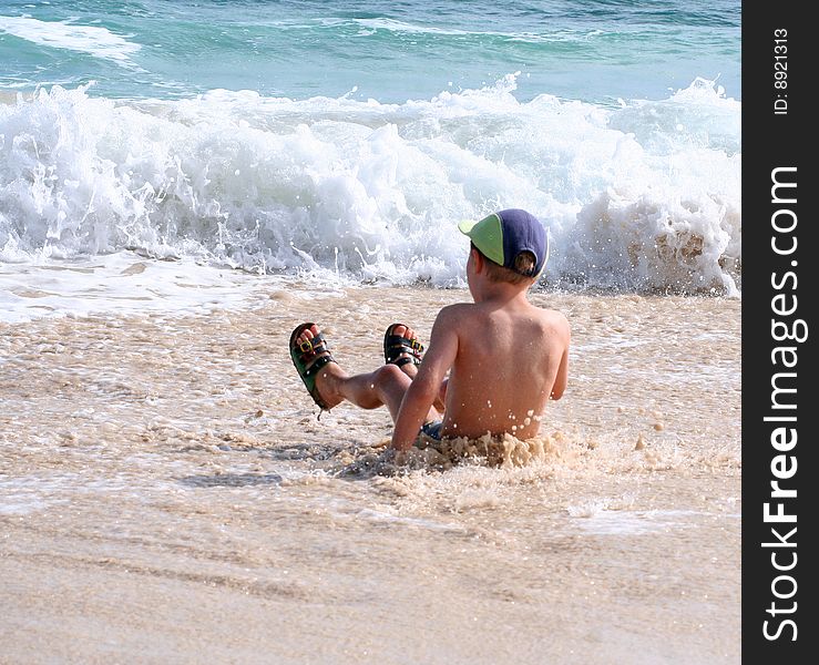 A young boy is playing on the beach