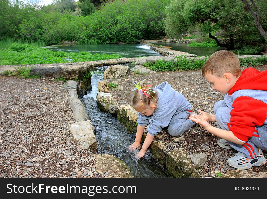 Little boy and girl playing with water. Little boy and girl playing with water
