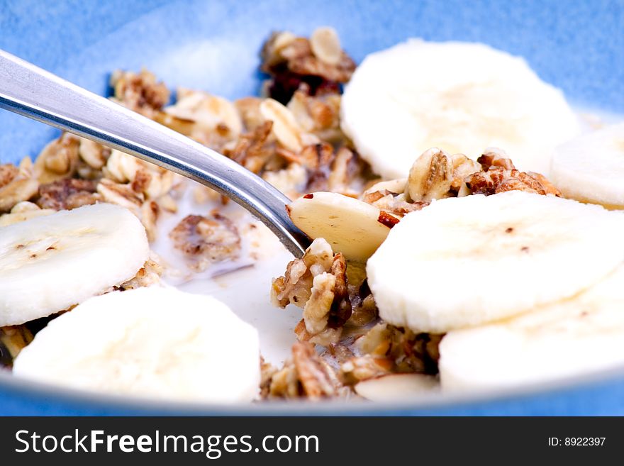 Detail of a bowl of muesli with spoon and banana slices. Detail of a bowl of muesli with spoon and banana slices