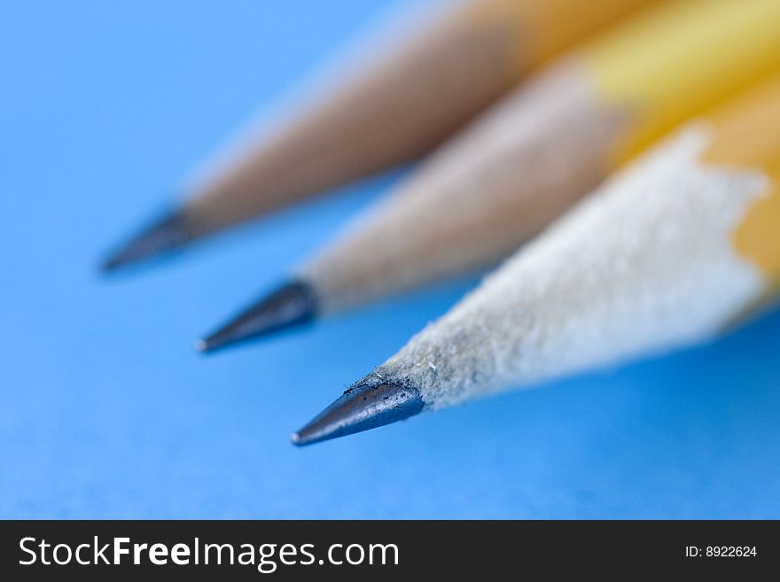 Three charp pencils against blue background. Three charp pencils against blue background