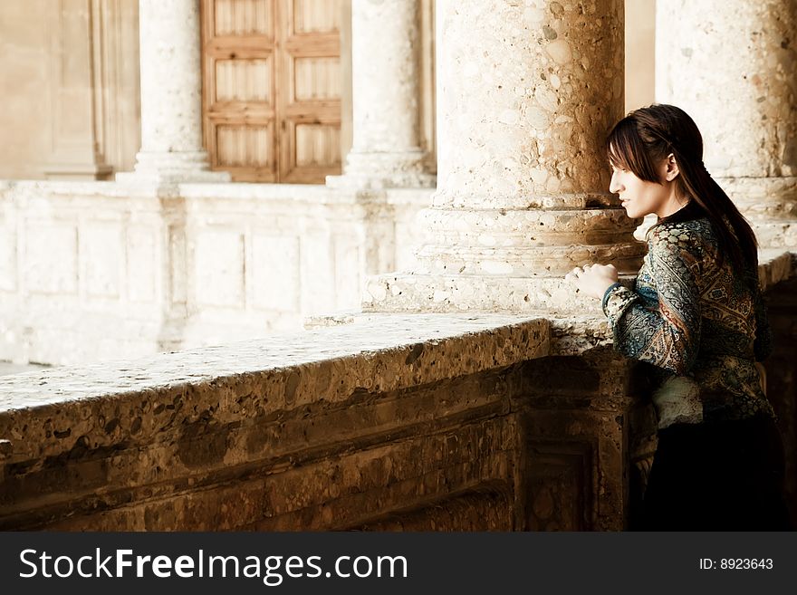 Young woman posing in old palace column. Young woman posing in old palace column.