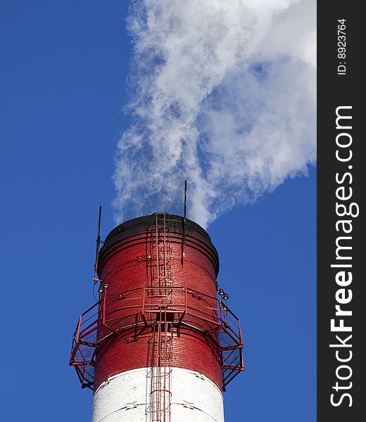 Smoke curling from a pipe of the industrial enterprise. Smoke curling from a pipe of the industrial enterprise