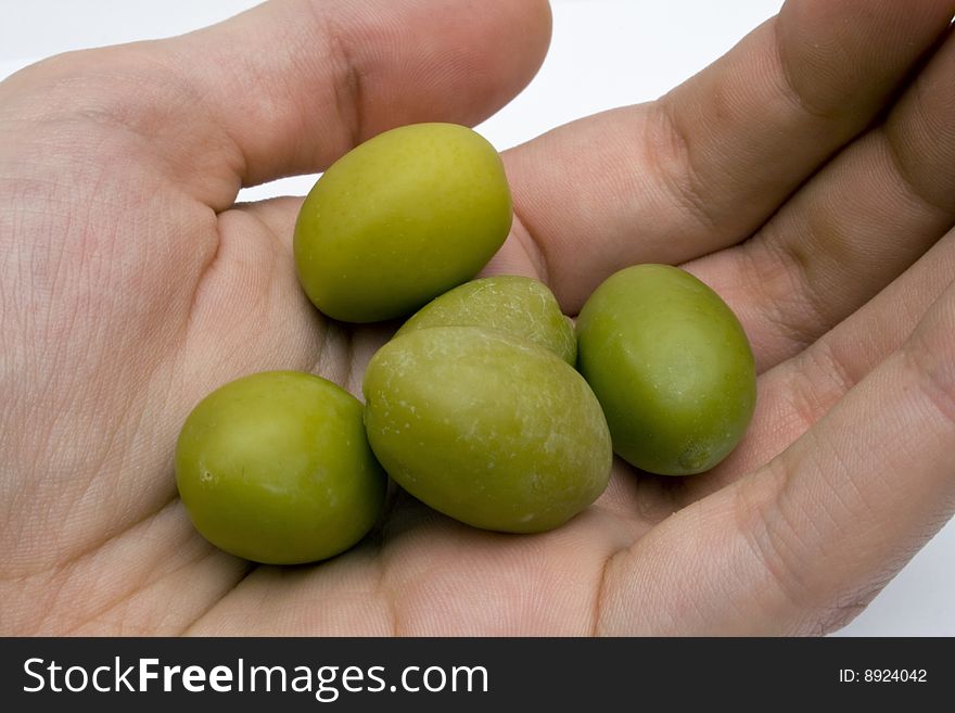 Man's hand holdin a group of olive