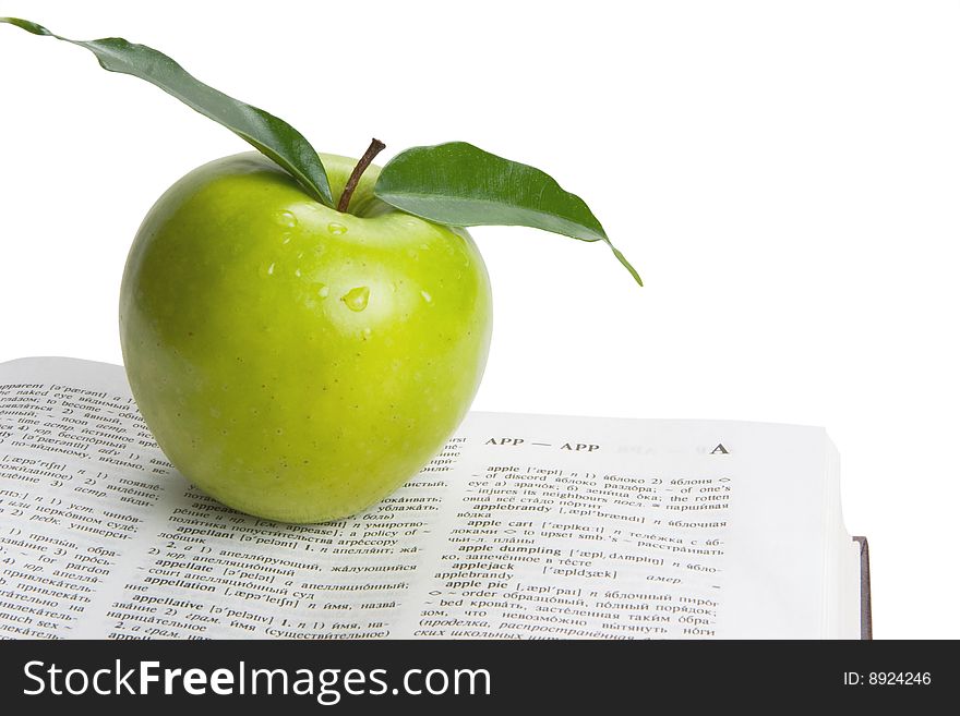 Book and green apple. White background. Book and green apple. White background