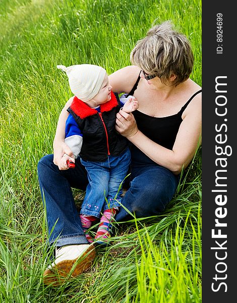 Small girl on the grass with grandmother. Small girl on the grass with grandmother