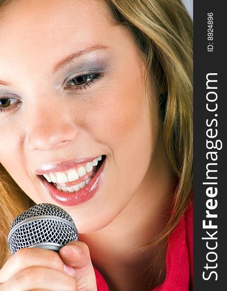 Portrait of a happy singing woman with a microphone. Portrait of a happy singing woman with a microphone