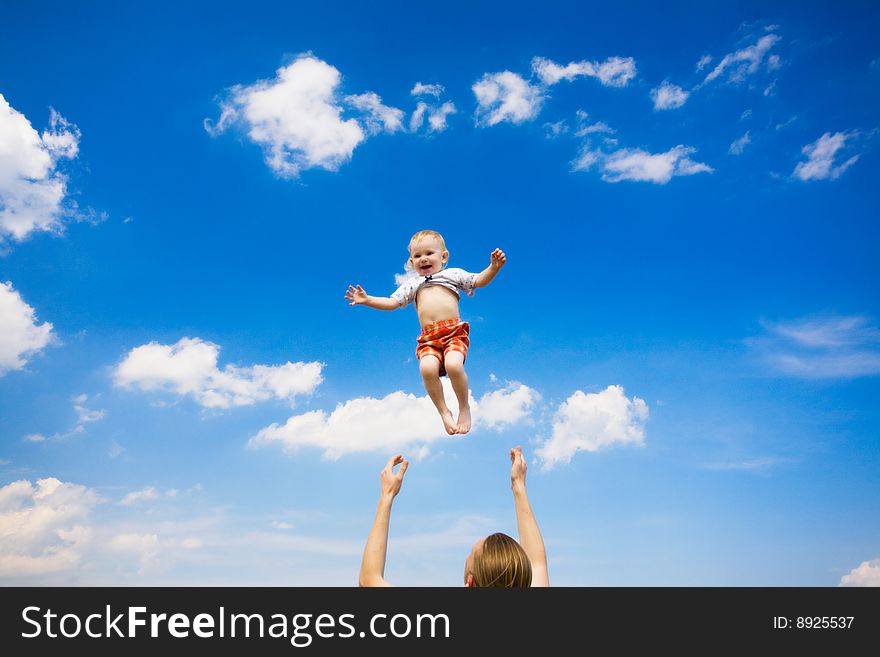 Father throw his daughter over blue sky. Father throw his daughter over blue sky