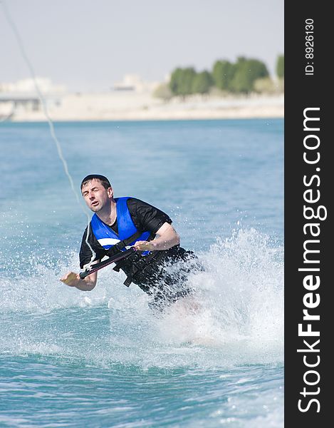 A wakeboarder enjoying the action of riding the wake of the boat, taking a fall. A wakeboarder enjoying the action of riding the wake of the boat, taking a fall.