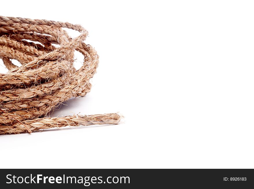 A horizontal view of a coil of rope on white with space for copy