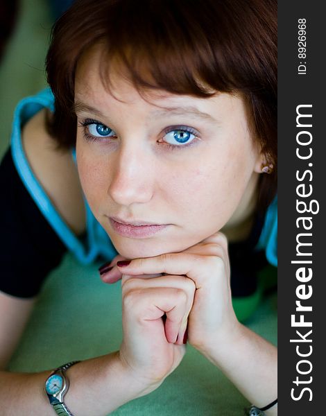 The girl looks expressive blue eyes, a blue T-shirt and looks forward. The girl looks expressive blue eyes, a blue T-shirt and looks forward