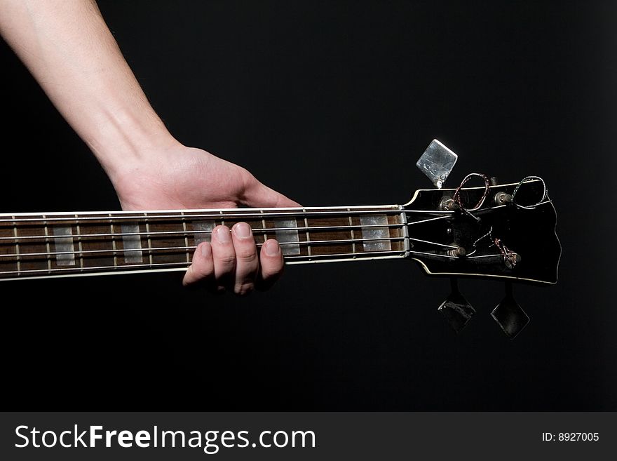 Musician with vintage bass guitar on black background.