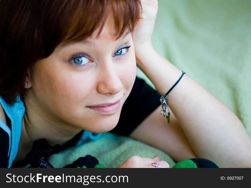 The girl looks expressive blue eyes, a blue T-shirt and looks forward. The girl looks expressive blue eyes, a blue T-shirt and looks forward