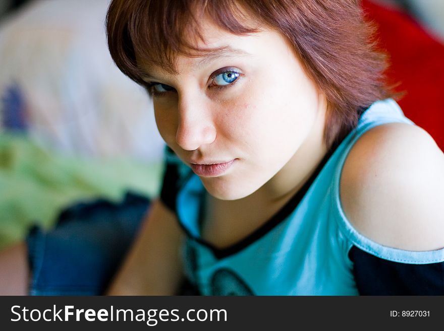 The girl looks expressive blue eyes, a blue T-shirt and looks forward. The girl looks expressive blue eyes, a blue T-shirt and looks forward