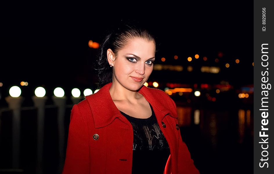 Young beautiful brunette in a coat walks on a night city. New photos every week. Young beautiful brunette in a coat walks on a night city. New photos every week