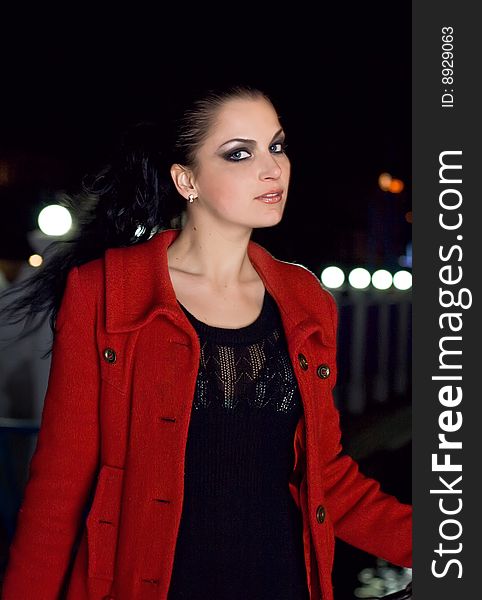 Young beautiful brunette in a coat walks on a night city. New photos every week. Young beautiful brunette in a coat walks on a night city. New photos every week