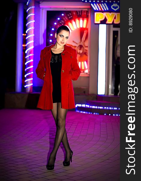 Young beautiful brunette in a coat walks on a night city. New photos every week. Young beautiful brunette in a coat walks on a night city. New photos every week