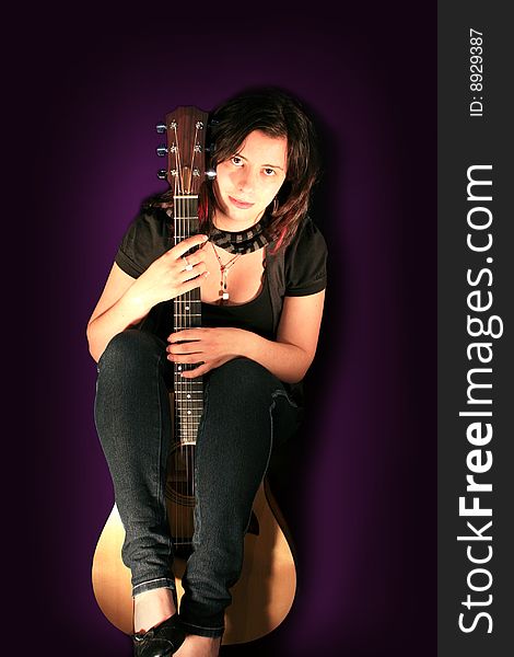 Beautiful Young Woman Holding an Acoustic Guitar with Purple Background. Beautiful Young Woman Holding an Acoustic Guitar with Purple Background