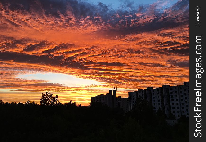A view of a city skyline with burning clouds in the sky. A view of a city skyline with burning clouds in the sky.