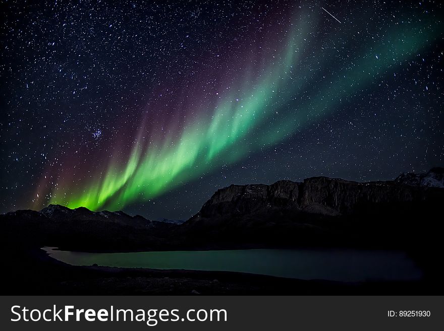 A starry sky over a lake with aurora on the sky. A starry sky over a lake with aurora on the sky.