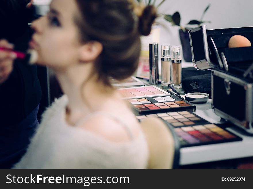 A make-up artist applying make-up on a woman. A make-up artist applying make-up on a woman.