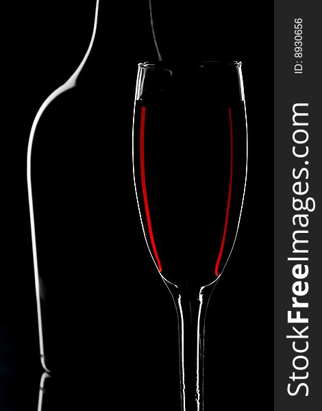 Wine glass and bottle isolated on black background. Wine glass and bottle isolated on black background