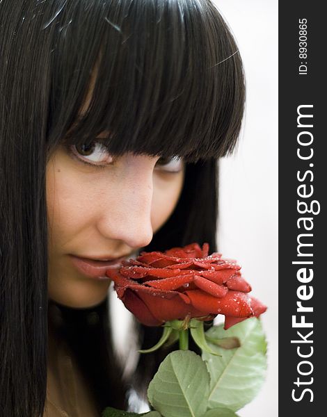 Girl sniffing beautiful flower - red rose. Girl sniffing beautiful flower - red rose