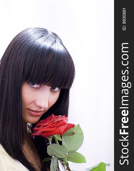 Girl sniffing beautiful flower - red rose. Girl sniffing beautiful flower - red rose